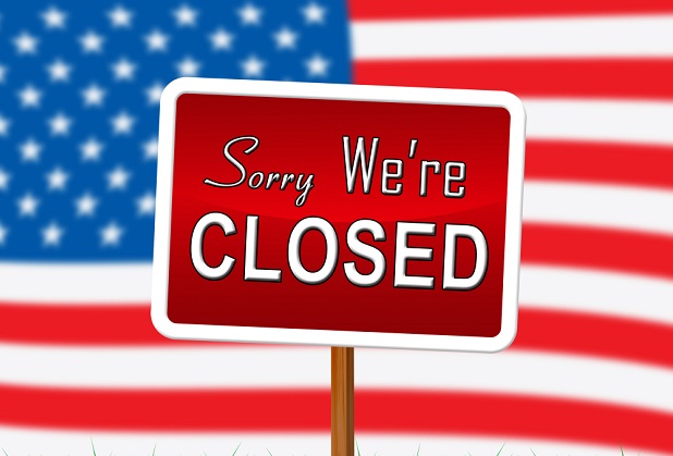 U.S. flag with sign saying Closed