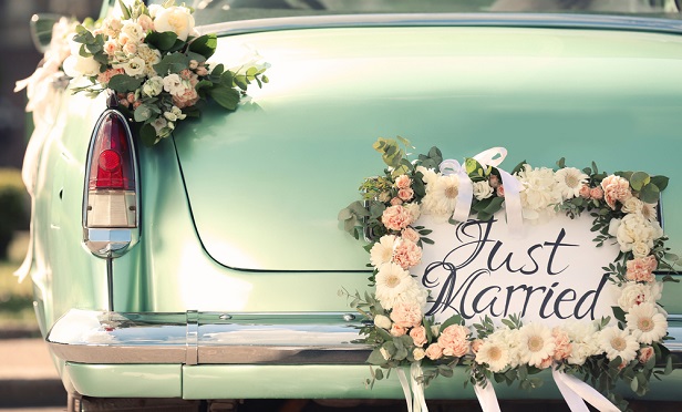 Just married sign and flowers on car