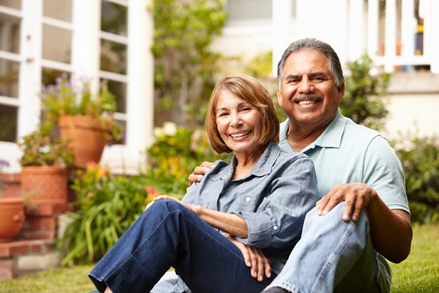 older couple sitting together on the grass smiling