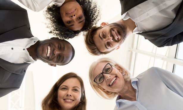 Circle of five employees smilling