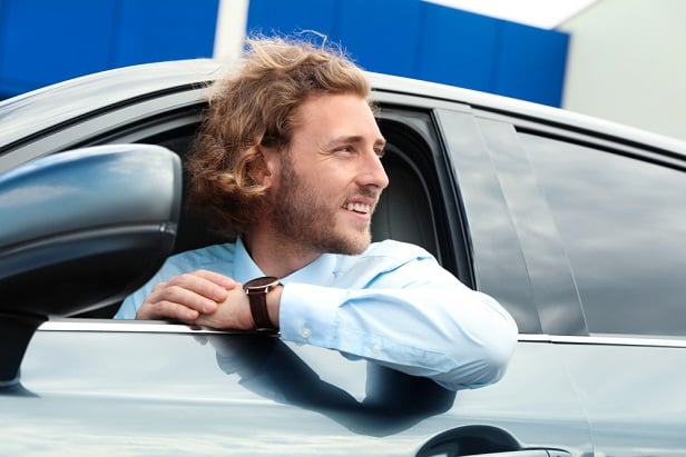 young man in tie in drivers seat