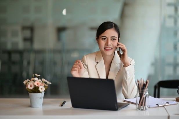 business woman at laptop, talking on her phone