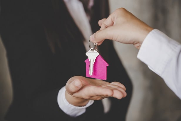 one hand giving another hand a set of keys