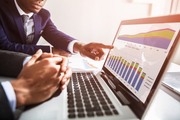 two business men looking at computer screen with charts