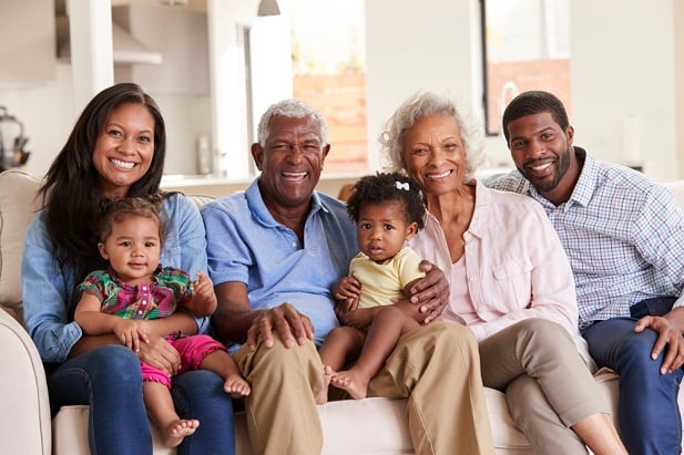 three generations of a family sitting on sofa