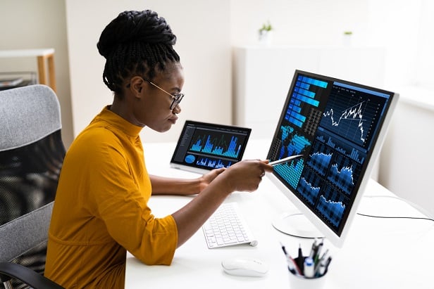 woman at desk peering at computer screen