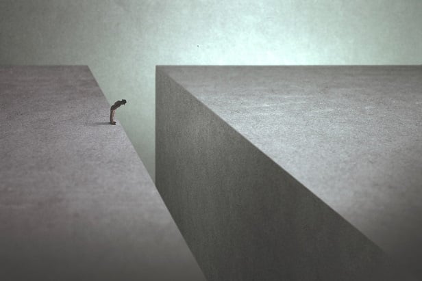 tiny figure at crevasse between two gray blocks