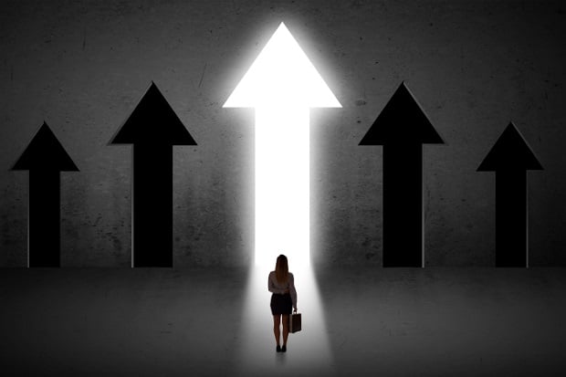 woman entering a giant door in shape of upward pointing arrow