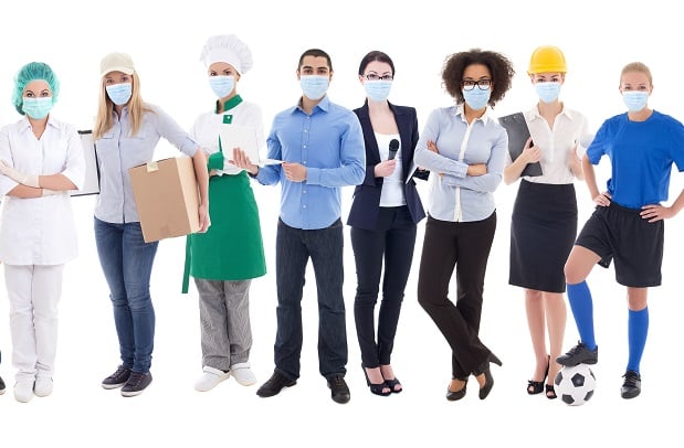 group of masked employees dressed in various uniforms and work clothes