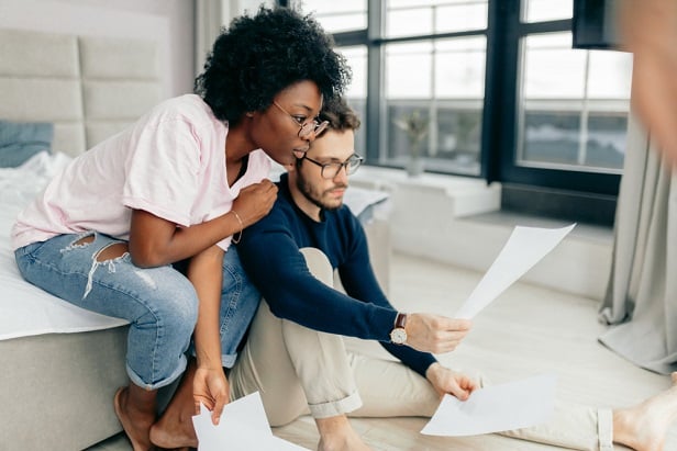 woman and man in living room looking at laptop