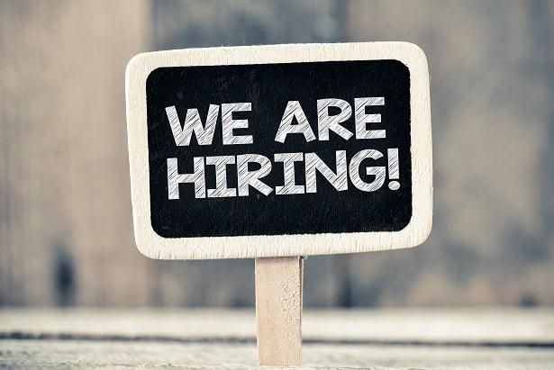 We are hiring handwritten with white chalk on a blackboard.