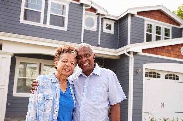 older couple standing outside home