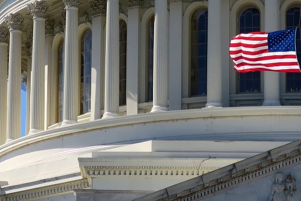 closeup of U.S. capitol dome with U.S. flag flying