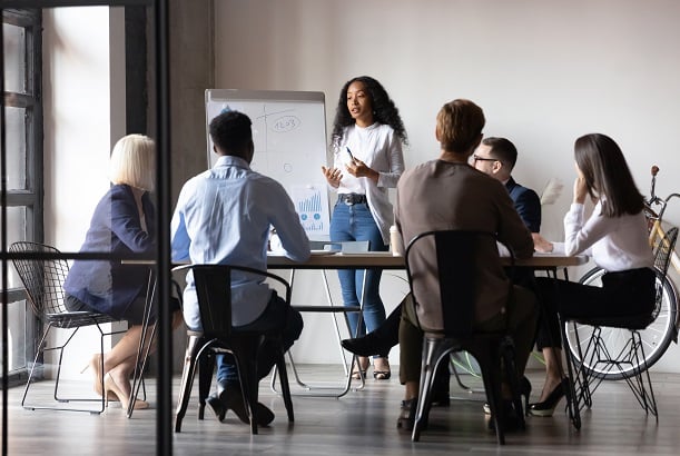 small group of employees listening to woman giving presentation