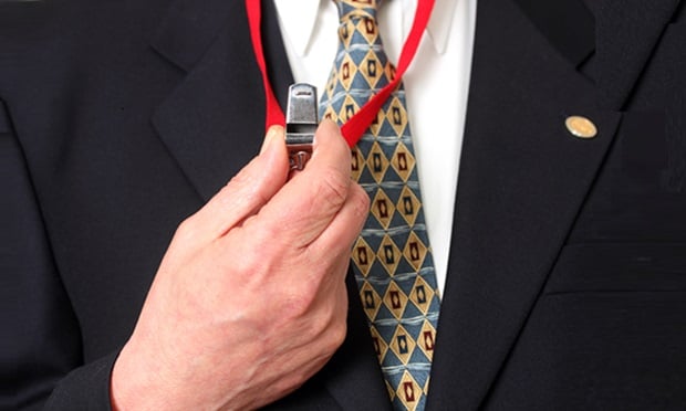 A person in a suit and tie wearing a whistle