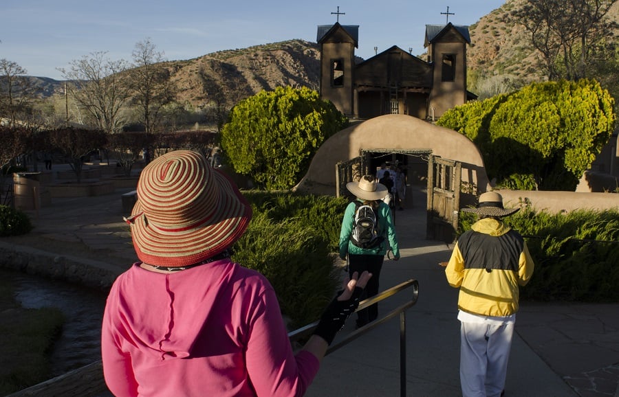 Navajo elder Betty Box, far right, accompanied by two friends from Colorado, enter the courtyard of El Santuario de Chimayo having made the pilgrimage north from Santa Fe, New Mexico. (AP Photo/Jeremy Wade Shockley)