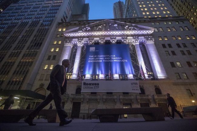 Person walking on Wall St at night