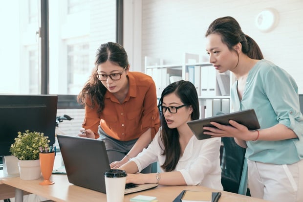 3 women in office looking at computer