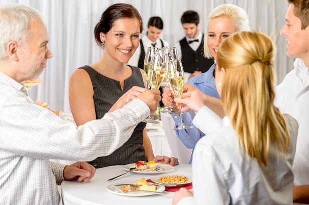 people raising glasses at a party