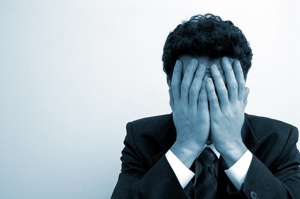 man with hands over face