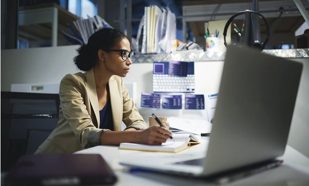 Woman sitting at desk late at night