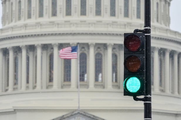 U.S. Capitol building with traffic light nearby that's green
