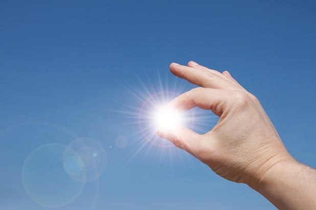 man holding sun in fingers lighter