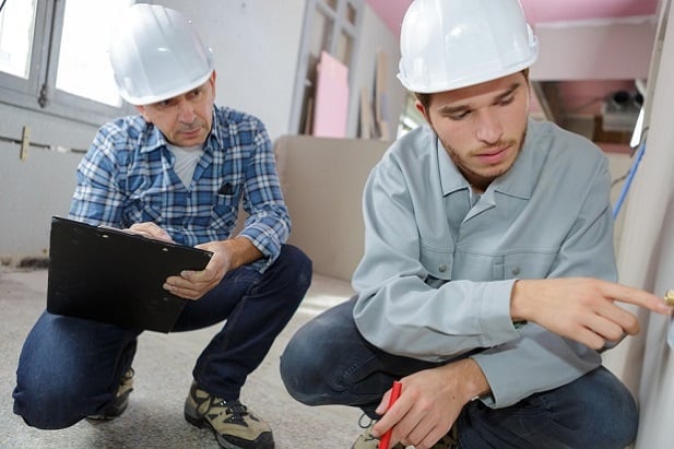 2 men in hardhats inspecting factory