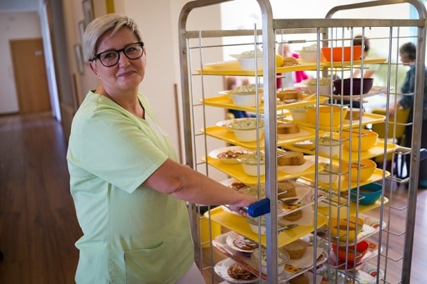 cafeteria worker with tray of foods