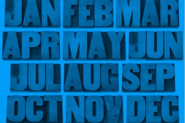 the months of the year abbreviations on wood blocks in a grid that is blue