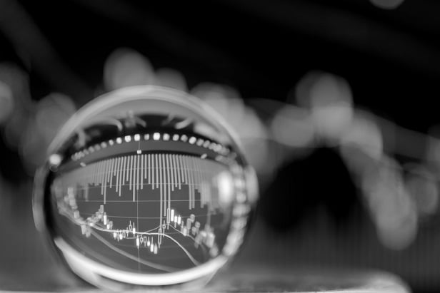 black and white photo of crystal ball with stock or financial chart inside it