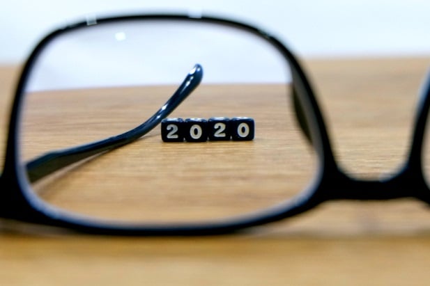 black eyeglasses on table with letters spelling 2020 visible behind them