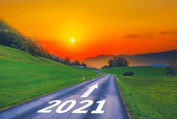 road with 2021 on it and arrow pointing to mountains and sunset or sunrise