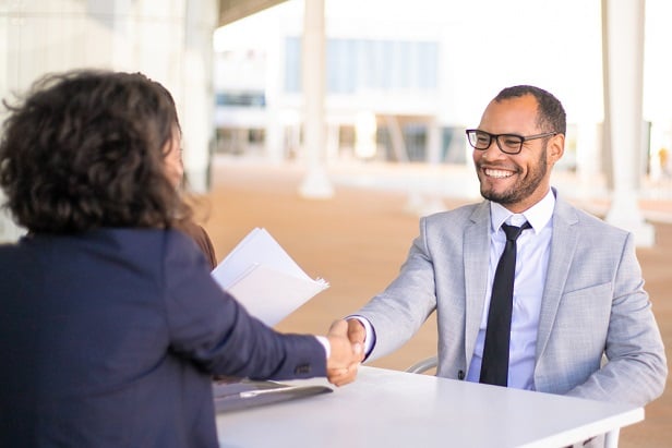 man and woman in business suits shaking hands