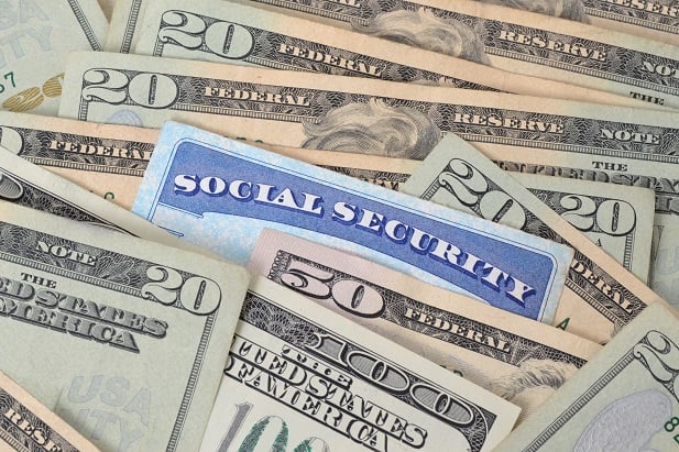 social security card nearly covered by money
