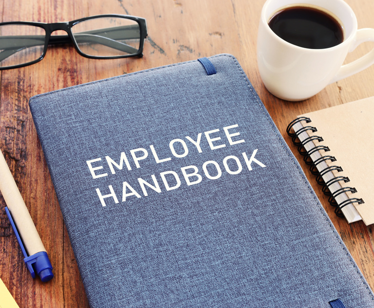 Concept image of employee handbook over wooden office table. top view. Credit: Tomertu/Adobe Stock.