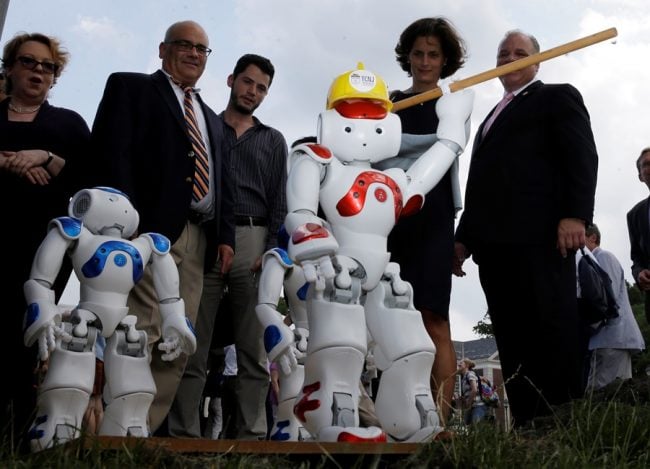 People standing around robots.