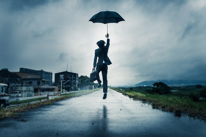 man jumping with umbrella