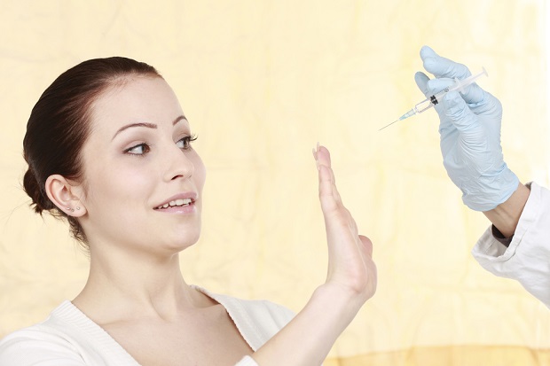 woman pushing away vaccine