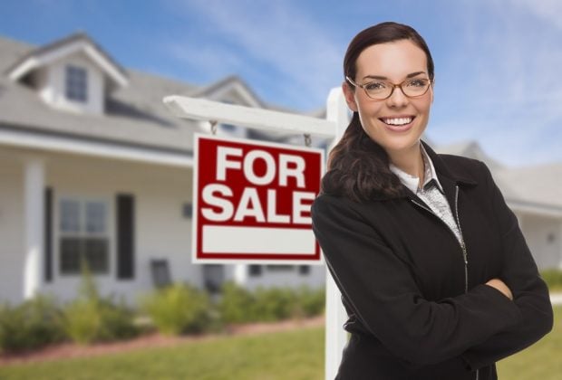 realtor in front of for sale sign