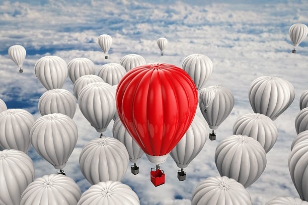 Red hot air balloon against sea of white balloons