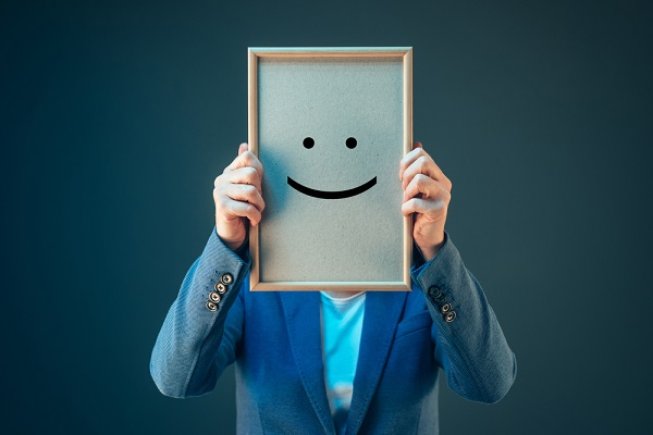 Person holding smiley face sign