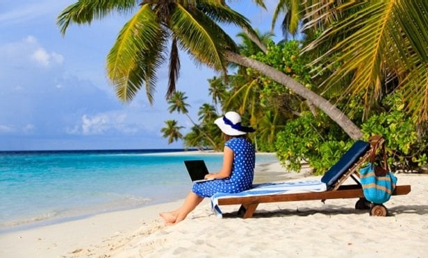 Woman on beach with laptop