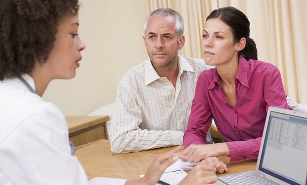 Man and woman speaking with doctor