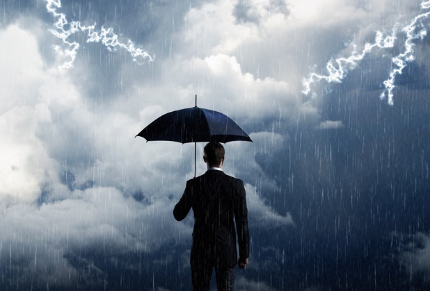 Man with umbrella facing storm