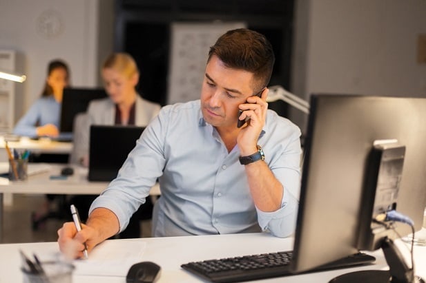 man on phone taking notes