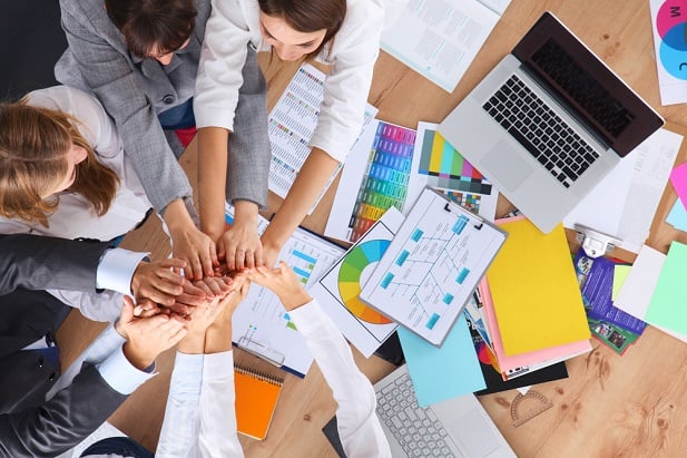 group of people putting hands on hands