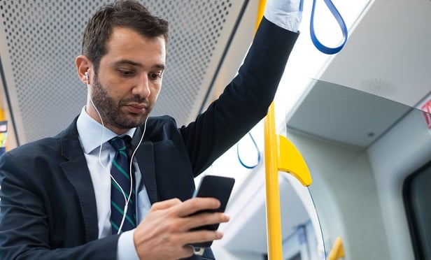 Businessman checking phone on train