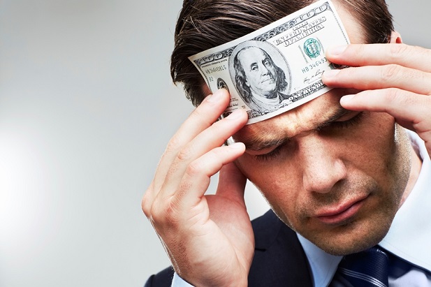 man with dollar bill pressed to forehead