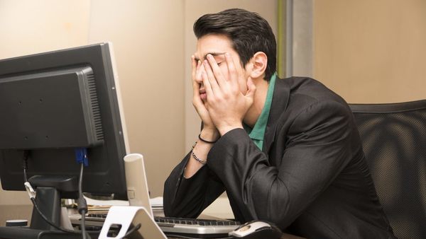 man at desk looking stressed